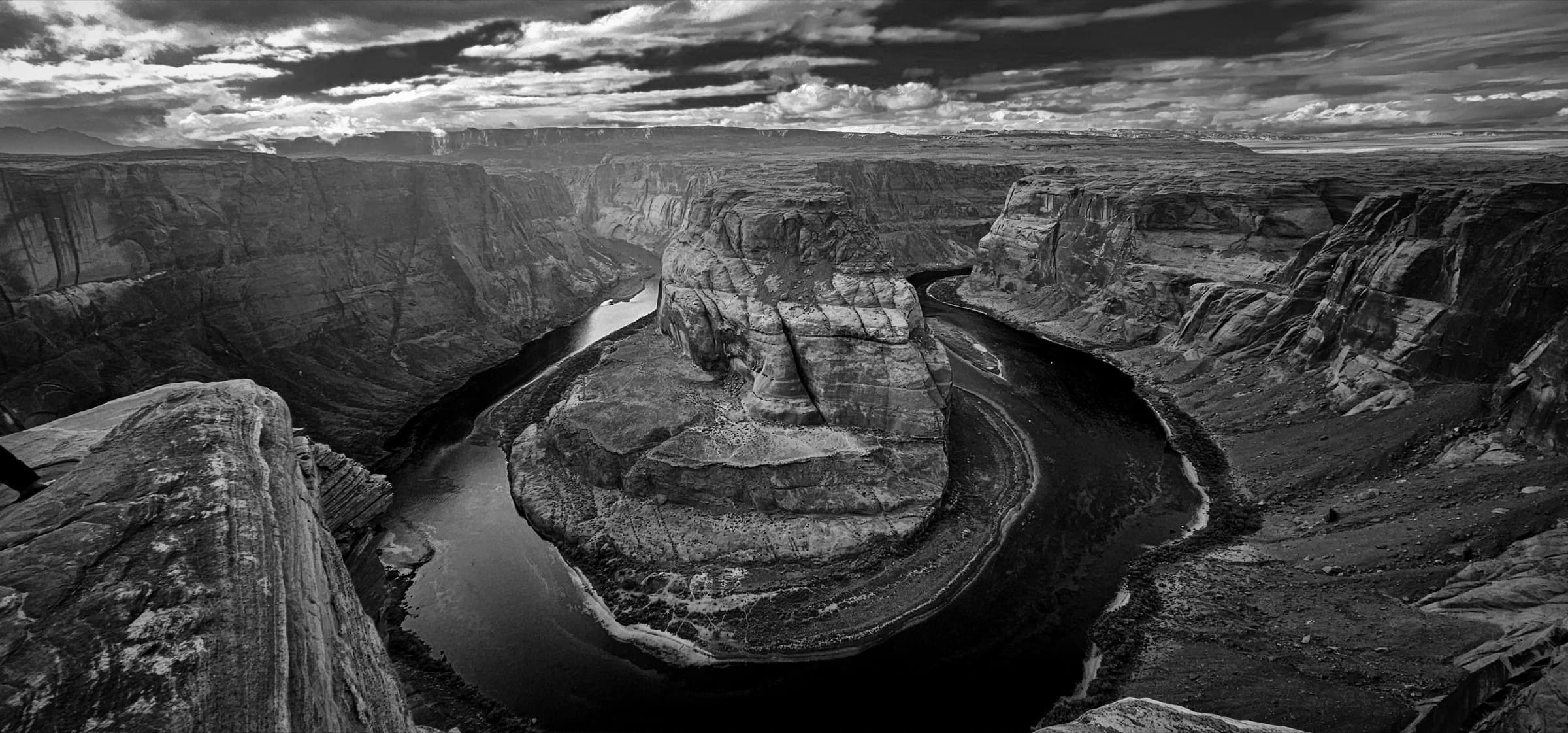 Horseshoe Bend — the Colorado River curving around a sandstone butte under a soft sky.